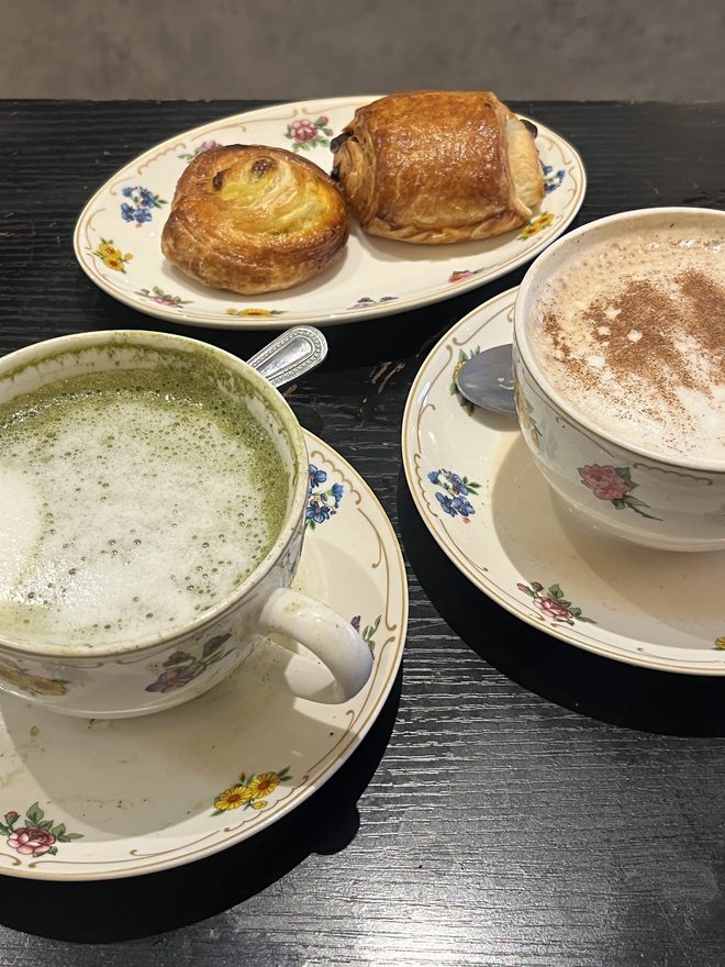 A shared table spread of pastries, matcha and cappuccino