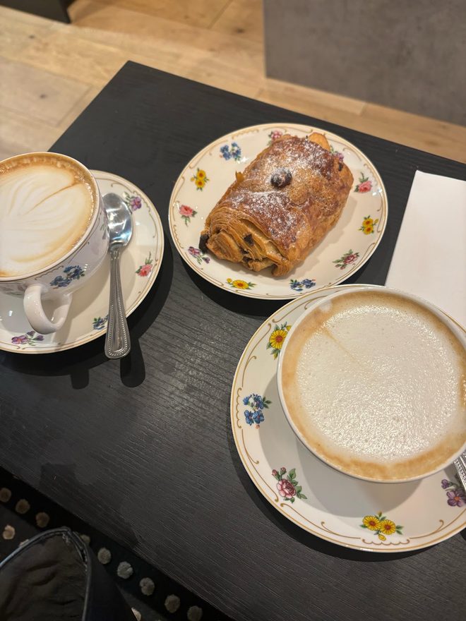 Two coffees and a chocolate pastry on a dark table